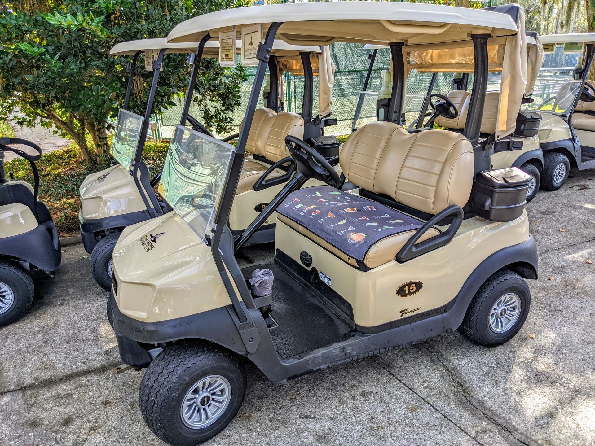 Tan golf carts parked in a row.